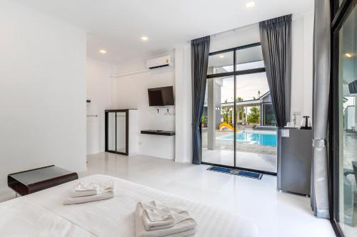 a bedroom with a bed and a pool at The Chill Villa Prachuap in Khao Khan Kradaj