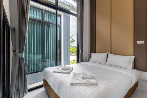 a bedroom with a bed and a large window at The Chill Villa Prachuap in Khao Khan Kradaj