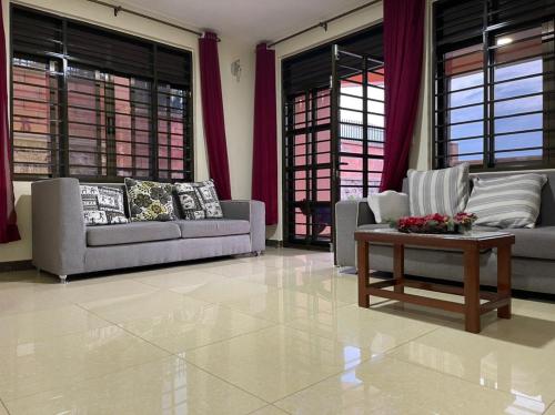 a living room with two couches and a coffee table at The Mugabis Spacious Private Room in Kigali