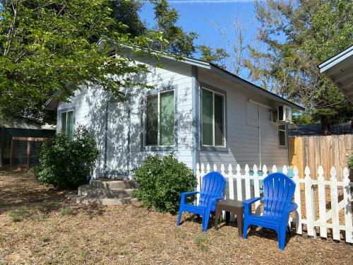 two blue chairs and a table in front of a house at Clearlake Cabins in Clearlake