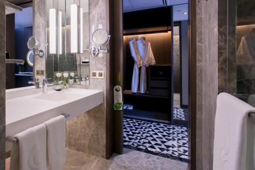 a bathroom with a sink and a mirror at Centara Grand At CentralWorld in Bangkok