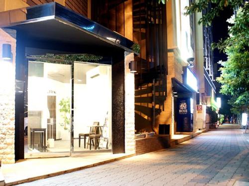 a store window on a city street at night at HOTEL LiVEMAX BUDGET Shinosaka in Osaka