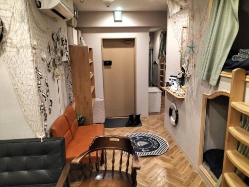 a living room with a couch and a chair at bnb plus Ueno Park Female only in Tokyo