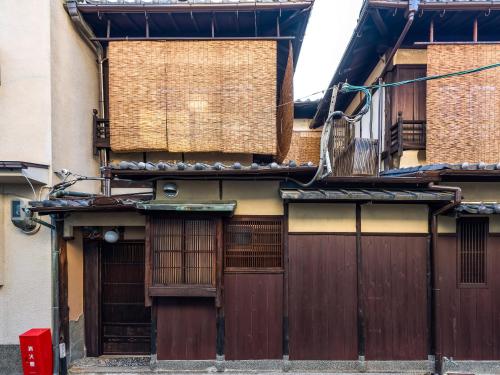 an old building with wooden doors and windows at 慶有魚·大松(Kyotofish·Oomatsu)*近祇園清水寺*地暖顶级桧木浴缸*枯山水庭院町屋 in Kyoto
