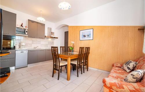 a kitchen and dining room with a table and a couch at 2 Bedroom Amazing Apartment In Modric in Rovanjska