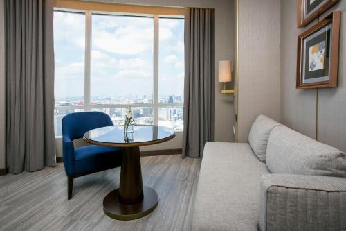 a living room with a couch and a table and a window at Centara Grand At CentralWorld in Bangkok
