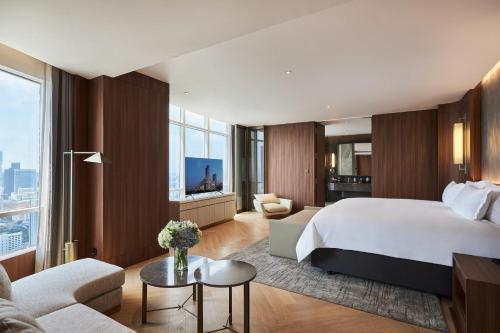 ein Schlafzimmer mit großem Bett und ein Wohnzimmer in der Unterkunft Centara Grand At CentralWorld in Bangkok