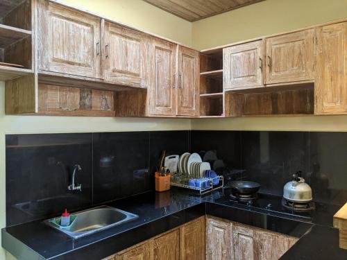 una cucina con mobili in legno e un lavello di The Suci Sari Ubud ad Ubud