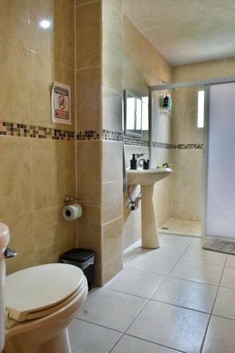a bathroom with a toilet and a sink at 2 VENATOR House Boutique in León