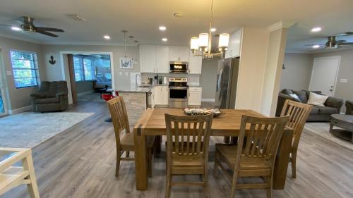 a kitchen and living room with a wooden table and chairs at Waterfront Hernando beach house on deep water canal w/dock, fishing, kayak in Hernando Beach