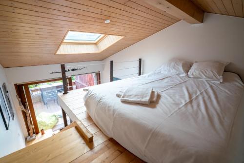 Schlafzimmer mit einem großen Bett und einem Dachfenster in der Unterkunft CABANA & Sunset - Terrasse , Parking & Lac in Veyrier-du-Lac