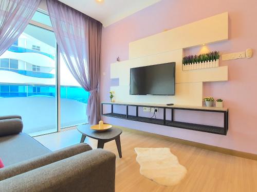 a living room with a tv on a wall at The Wave Suites Melaka in Melaka