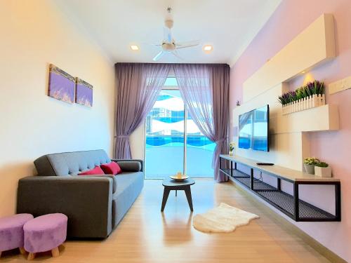 a living room with a couch and a tv at The Wave Suites Melaka in Melaka