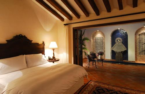 a bedroom with a bed and a large glass doorway at Hacienda San Angel in Puerto Vallarta