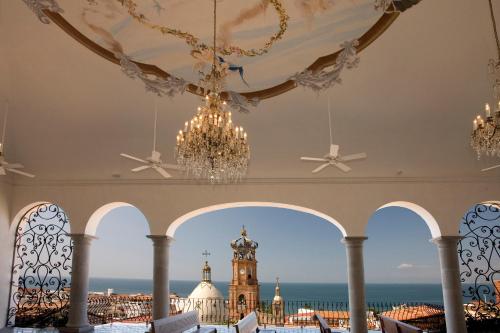 a room with a chandelier and a clock tower at Hacienda San Angel in Puerto Vallarta