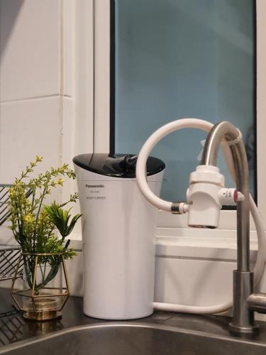 a bucket sitting on a kitchen counter next to a sink at The Wave Suites Melaka in Melaka