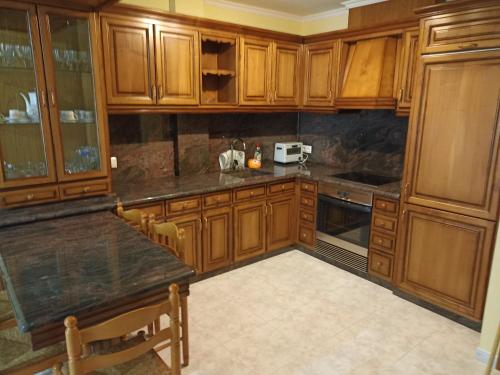 een keuken met houten kasten en een aanrechtblad bij Parque de los Patos in Cedeira