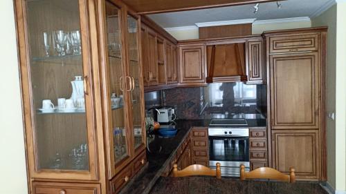 een keuken met houten kasten en een kookplaat met oven bij Parque de los Patos in Cedeira