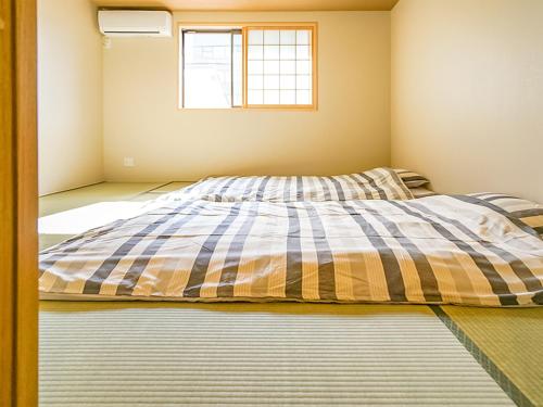 a bed in a room with a window at 慶有魚·八坂(Kyotofish·Yasaka)*近清水寺祗园5分钟*庭院地暖浴缸*京都民宿认证 in Kyoto