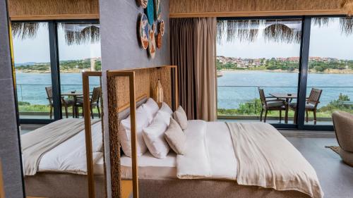 a bedroom with a bed with a view of the water at Sa'Rezya Hotel in Cesme