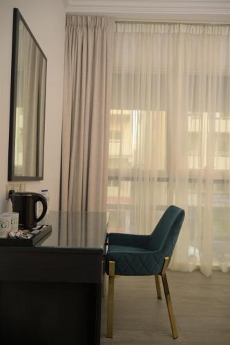 a desk with a chair in front of a window at Garden City Hotel Dubai in Dubai