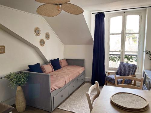 a room with a bed with a window and a table at ☆ Sur les toits de Blois ☆ T2 avec vue Château in Blois