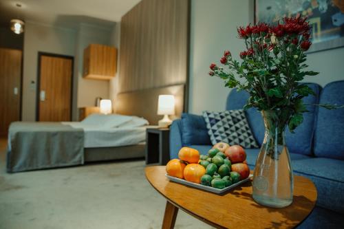 una sala de estar con una mesa con un jarrón de flores en Abaash Hotel Afon en Novy Afon