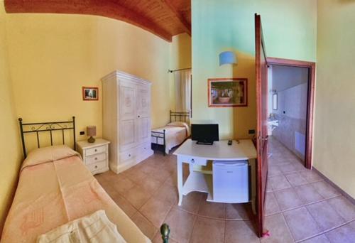 a bedroom with a bed and a desk with a computer at Su Massaiu in Turri