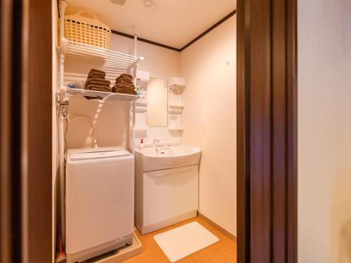 a small bathroom with a white refrigerator and a sink at 慶有魚·二条城(Kyotofish·Nijojo)*百年町屋青石板*庭院浴缸*二条站6分钟*民宿认证 in Kyoto