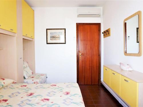 um quarto com uma cama, uma cómoda e um espelho em Charming holiday home in Porto Santa Margherita with terrace em Porto Santa Margherita di Caorle