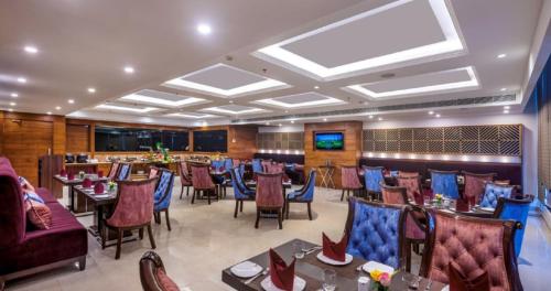 a restaurant with tables and chairs in a room at Lords Inn Chandigarh Zirakpur in Zirakpur