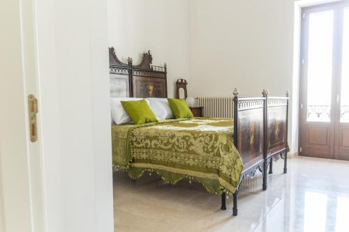 a bedroom with a bed with a green comforter at Casa Sampietro in Locorotondo