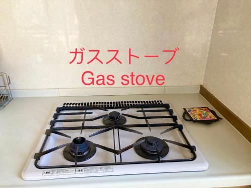 a gas stove in a kitchen with writing on the wall at 富士の樱House 宝栄 in Fujikawaguchiko