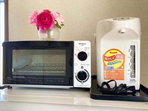 a microwave sitting on a counter next to a flower at 富士の樱House 宝栄 in Fujikawaguchiko