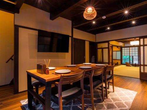 a dining room with a wooden table and chairs at Kyotofish·Masuya*Reformed Machiya*Gardenview Bath in Kyoto