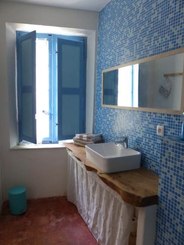 a bathroom with a white sink and a window at Maison Mômes in Bize-Minervois