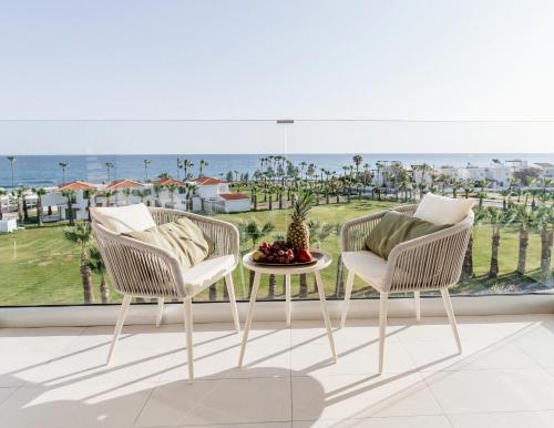 two chairs and a table on a balcony with a view of the ocean at At Herbal Boutique Hotel & Spa in Protaras