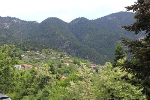a village on a hill with mountains in the background at Elatou in Áno Khóra