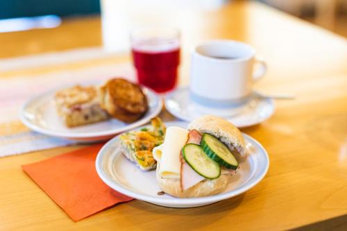 zwei Teller mit Sandwiches und eine Tasse Kaffee auf dem Tisch in der Unterkunft B&B Lomamokkila in Savonlinna