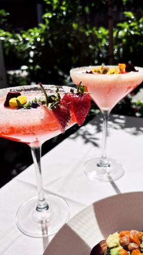 two cocktails sitting on top of a table at Old Foundry Hotel by Ideas Cartel in Cape Town