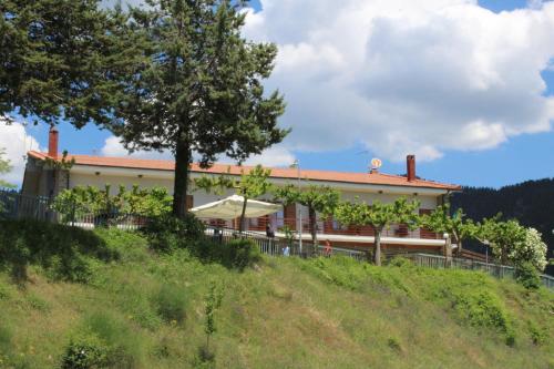 a building on top of a hill with a tree at Elatou in Áno Khóra