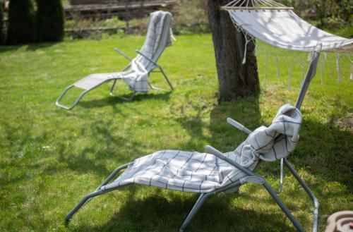 two chairs sitting in the grass in a yard at Dom całoroczny nad Bugiem in Wasilew Szlachecki