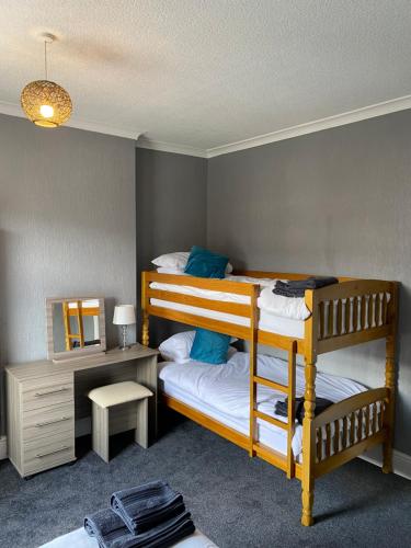 a bedroom with two bunk beds and a desk at Freya House in Gainsborough