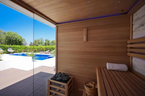 a sauna with a view of a swimming pool at Villa Pino with Pool, Sauna & Jacuzzi in Petrcane