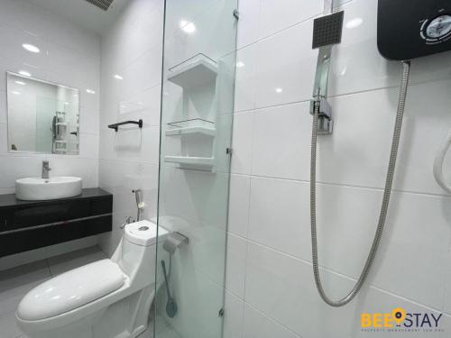 a white bathroom with a shower and a toilet at The Wave Suites Melaka in Melaka