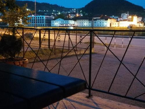 a bench on a balcony with a view of a beach at Apartman Dukat in Višegrad