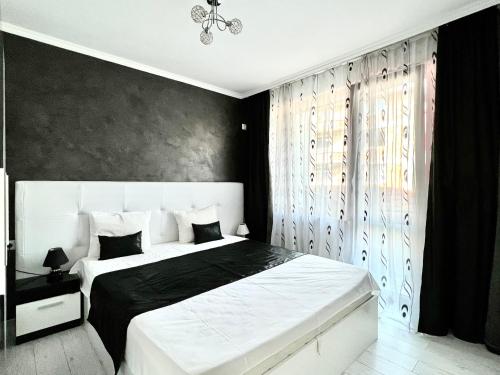 a bedroom with a large bed with a black wall at TEA Apartments in Pomorie