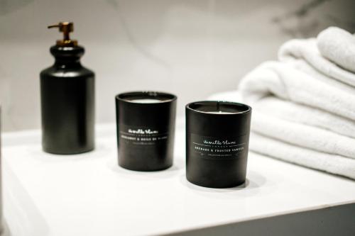 two black candles sitting on a shelf in a bathroom at At Herbal Boutique Hotel & Spa in Protaras