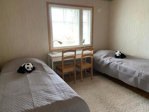 1 dormitorio con 2 camas, escritorio y silla en Moksunsalo en Ähtäri
