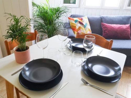 - une table avec deux assiettes noires et des verres à vin dans l'établissement Appartement 1BR near Monaco, à Beausoleil